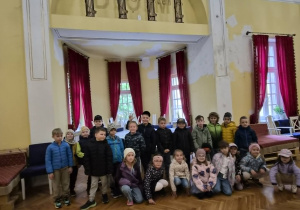 Dzieci pozuja do zdjęcia na tle teatru Dom