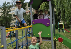 Dzieci bawią się na urządzeniach terenowych