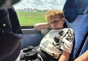 Chłopiec śpi w autokarze w drodze do przedszkola