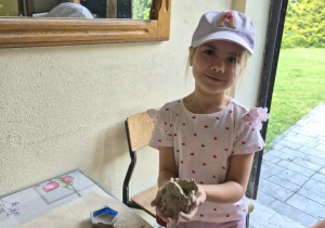 Dziewczynka prezentuje swoją prace z gliny