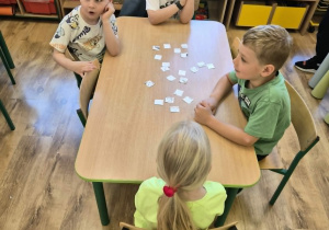 Dzieci układają puzzle przy stole