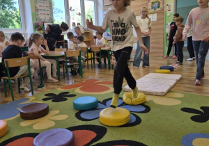 Dzieci uczestniczą w zabawie z torem przedszkód