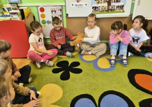 Dzieci przedstawiają się uczniom podając sobie pluszowego misia