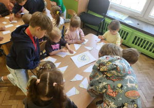 Dzieci z gr 3 układają puzzle przy stole