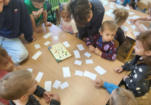 Dzieci z gr 3 układają puzzle przy stole