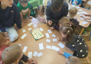 Dzieci z gr 3 układają puzzle przy stole