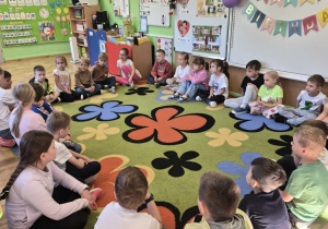 przedszkolaki słuchają czytanych bajek przez kolegów ze szkoły