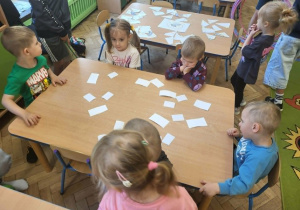 Dzieci z gr 3 układają puzzle przy stole