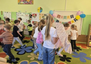 Dzieci uczestniczą w zabawie z parasolem