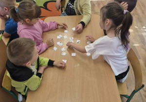 Dzieci układają puzzle przy stole