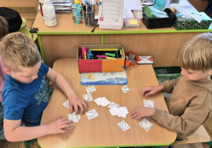 Dzieci układają puzzle przy stole