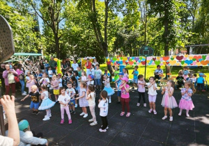 Dzieci tańczą na boisku dla swoich rodziców