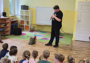 Pan gra na instrumencie do przemieszczającej się torby