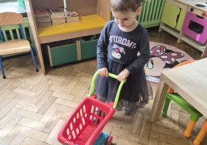 Dziewczynka bawi się wózkiem spożywczym