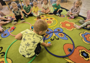 Chłopiec dopasowuje kolor piłeczki do odpowiedniego koła