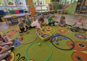 Dziewczynka dopasowuje kolor piłeczki do odpowiedniego koła