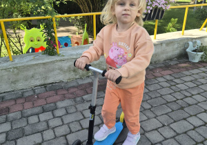 dziewczynka jeżdzi na hulajnodze
