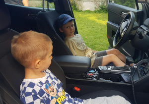 dzieci siedzą w radiowozie