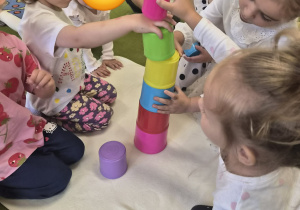Dzieci układają kolorową wieżę