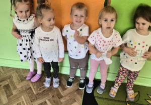 dzieci prezentują kolorowe kropki na ubraniach