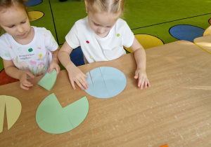Dwie Dziewczynki układają koła pocięte na elementy