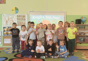 Grupowe zdjęcie dzieci ubranych w koszulki z kropkami.