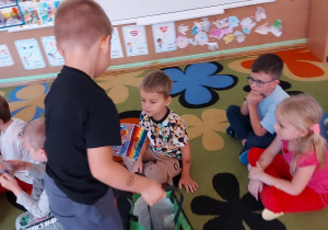 Chłopiec rozdaje upominki dzieciom.