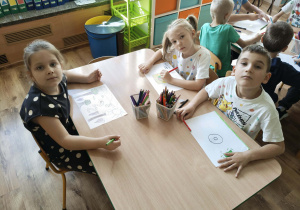 Dzieci przekształcają kropkę w rysunek.