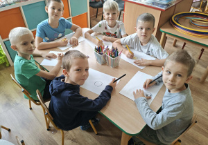 Dzieci przekształcają kropkę w rysunek.