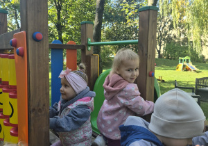 dzieci bawią się na urządzeniu terenowym