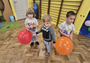 trzech chłopców tańczy z balonami