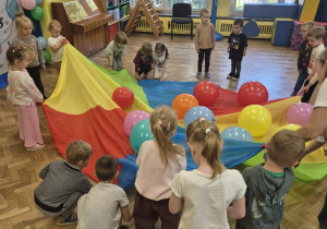 dzieci bawią się z panią chustą animacyjną i balonami
