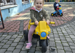 dzieci jeżdźą rowerkami po tarasie