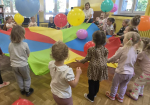 dzieci podrzucają balony na chuście