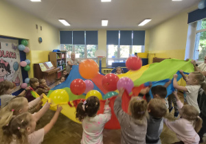 dzieci podrzucają balony na chuście