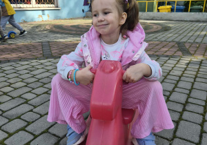 dziewczynka buja się na koniku