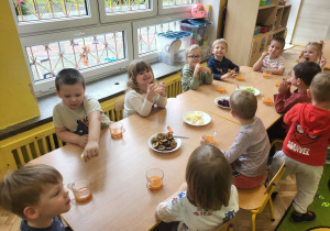 Dzieci częstują sie jesiennymi warzywami i owocami