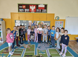 Dzieci stoją dookoła chłopca w koronie