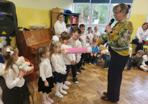 Pani dyrektor pasuje dzieci dmuchaną kredką
