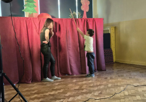 Chłopiec przegania lalkę -gąskę patykiem