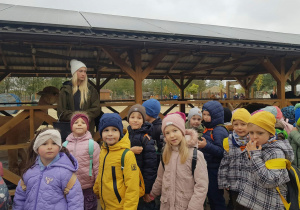 Dzieci stoją przy alpakach.