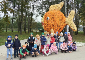 Dzieci stoją przy rybie z dyń.