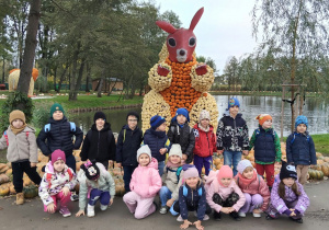 Dzieci stoją przy wiewiórce.