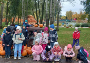 Dzieci stoją na tle traktora.