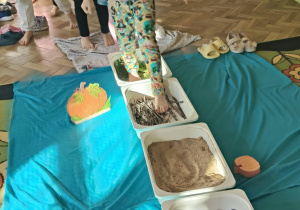 Dziewczynka idzie przez ścieżkę sensoryczną.