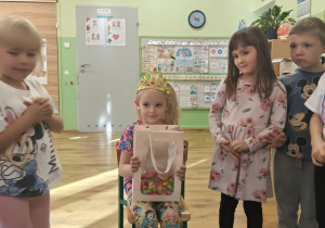 Dzieci stoją wokół jubilatki.