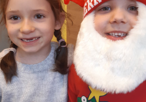 Na zdjęciu widać od lewej dziewczynkę w opasce świątecznej oraz chłpca przebranego za mikołaja