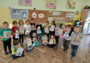 Dzieci z gr 2 pozują do zdjęcia z narysowanymi laurkami