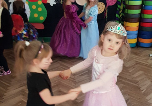 Dziewcznka przebrana za kota i księżniczkę tańczą