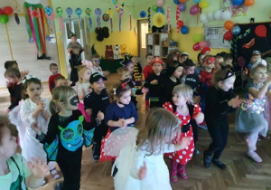 Dzieci przebrane za księżniczki, biedronki, spajdermenów itp tańczą na balu karnawałowym